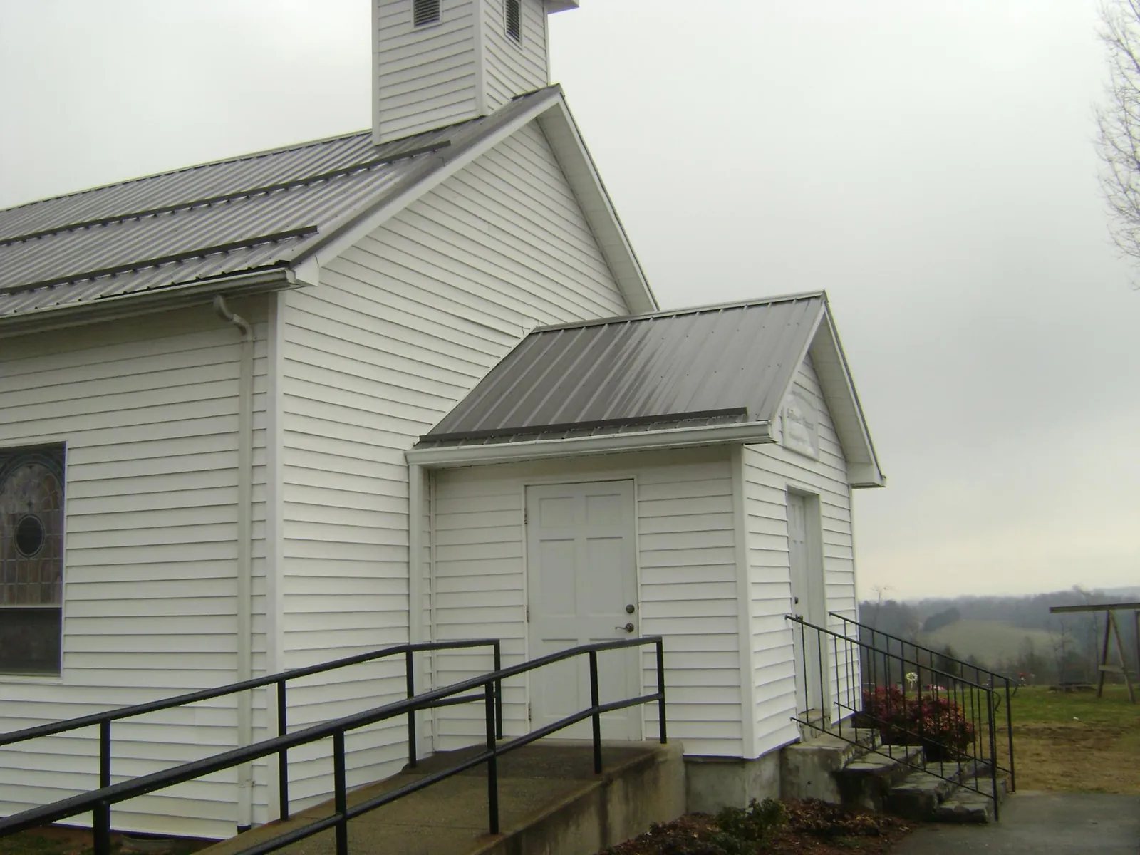 Gray metal roof on a white clapboard church with a steeple in Newport